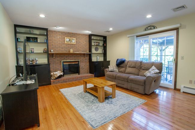 Family room right off the kitchen with beautiful hardwood floors and slider to the deck. | Image 8