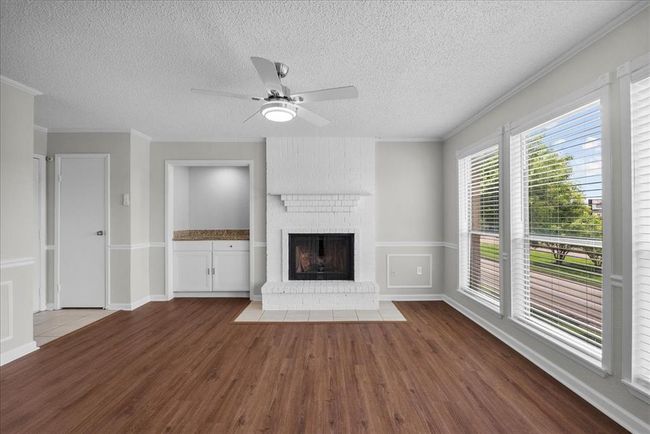The white brick fireplace steals the show as the heart of this space. Cozy, stylish, and oh-so photo-worthy. Bonus, A chic little dry bar ready for wine nights or coffee refills. | Image 6