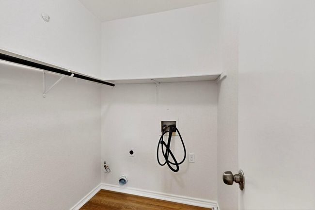 Washroom with hookup for a gas dryer, washer hookup, dark wood-style floors, and baseboards | Image 26