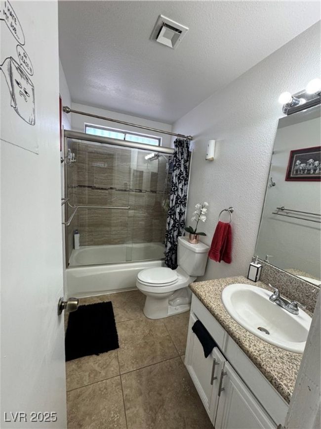 Full bathroom with shower / bathtub combination with curtain, vanity, toilet, tile patterned flooring, and a textured ceiling | Image 10