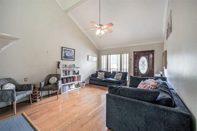 High ceilings & a fireplace are featured in this spacious living area. | Image 6