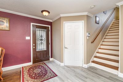 Entryway with hardwood / wood-style floors, a textured ceiling, and crown molding | Image 3