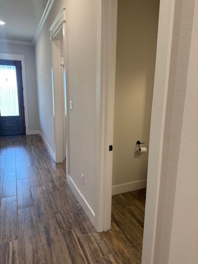 Hallway featuring ornamental molding and dark wood-type flooring | Image 6