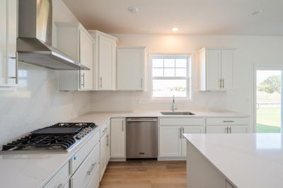 Photo is of the actual home. Open and naturally bright, the home's kitchen space is highly desirable and features a large kitchen island serving as the perfect centerpiece for cooking and entertaining! | Image 3