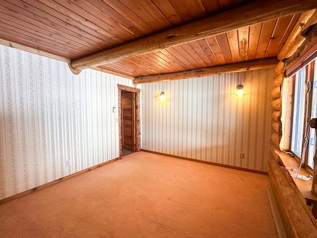 Carpeted empty room featuring beam ceiling and wooden ceiling | Image 35