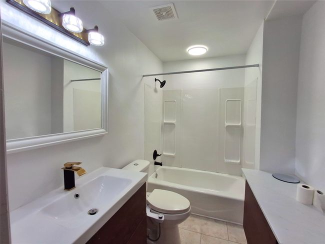 Full bath featuring vanity, toilet, tile patterned floors, and shower / bathtub combination | Image 18