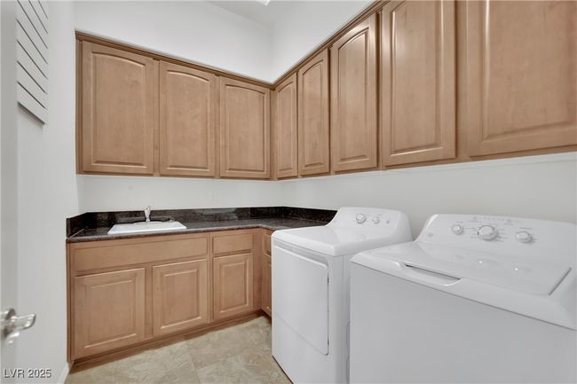 Washroom featuring washer and dryer, cabinet space, and a sink | Image 33