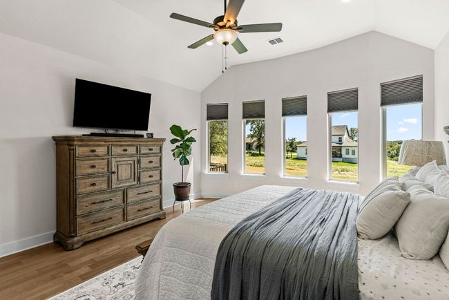 Bedroom featuring lofted ceiling, baseboards, visible vents, and wood finished floors | Image 24
