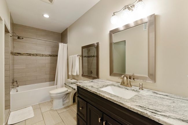 Second upstairs bathroom also features a separate tub and shower with more beautiful tile work and heated floors | Image 29