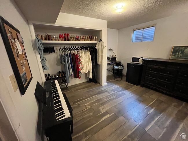 Bedroom with a textured ceiling, dark wood-style floors, and a closet | Image 28