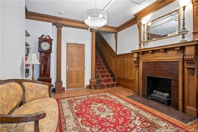 Living room with crown molding, a fireplace, and decorative columns | Image 2