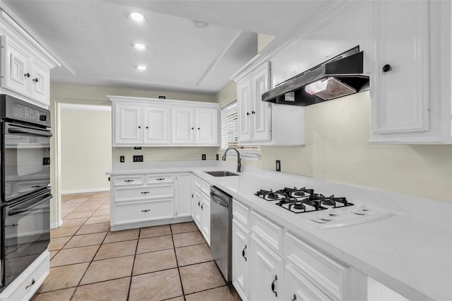 This modern kitchen features white cabinetry, laminated countertops, and stainless steel appliances—combining style and everyday function. | Image 8