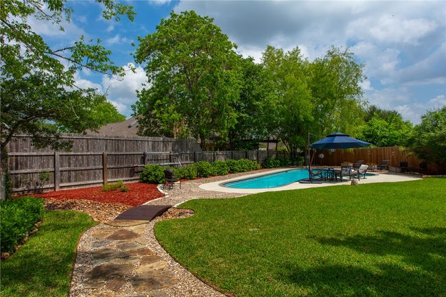 View of pool with a fenced backyard, a patio area, and a lawn | Image 35
