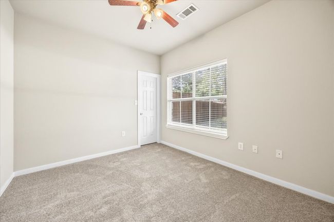 Carpeted spare room featuring baseboards, a ceiling fan, and visible vents | Image 19
