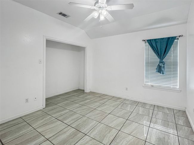 Unfurnished room with a ceiling fan and vaulted ceiling | Image 11