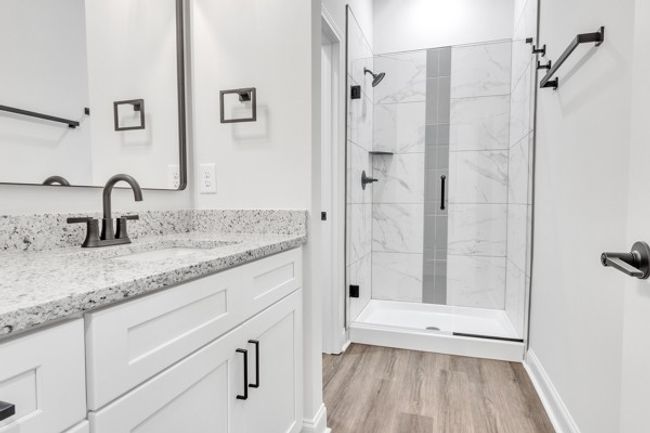 Spacious primary bath with granite, elegant tile and modern fixtures, decor & lighting. With the 10 ft ceilings and glass shower it has a true spa feeling! | Image 28