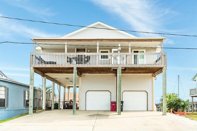 This elevated coastal home features a spacious covered deck, two-car garage, and ample driveway. Ideal for enjoying outdoor views. | Image 31