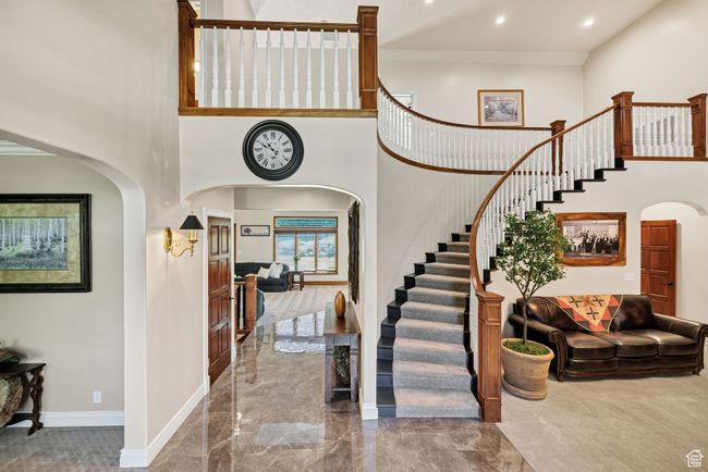 Entrance foyer featuring arched walkways, a towering ceiling, stairway, marble tiled floors, and recessed lighting | Image 19