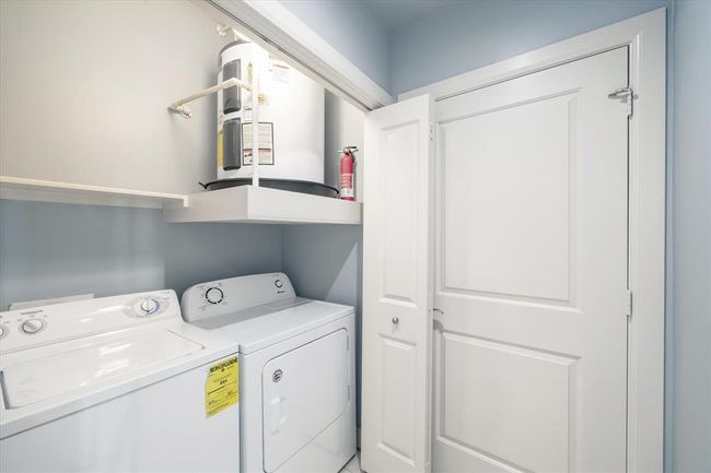 Spacious laundry area featuring a full-size washer and dryer. These appliances offer plenty of capacity for handling large loads, making laundry day more efficient. The area is thoughtfully designed for convenience and ease of use, fitting seamlessly into the home's functional layout. | Image 16