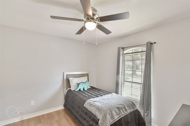 Bedroom with light wood-type flooring and ceiling fan | Image 9