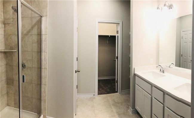 Full bath featuring a shower stall, a spacious closet, and double vanity | Image 18