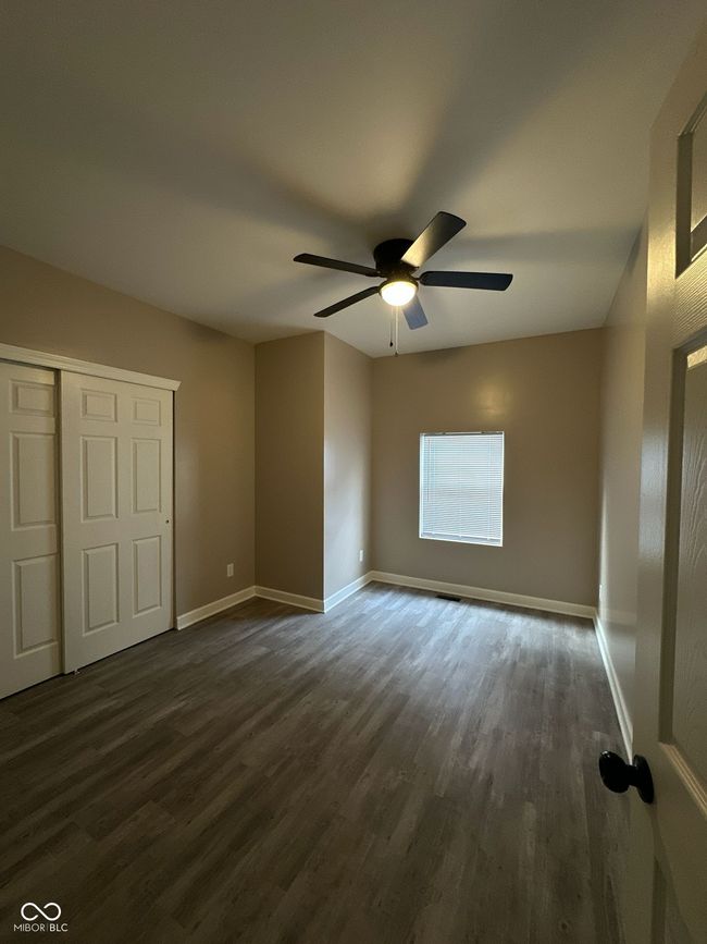 Unit 1 - 2nd unfurnished bedroom with dark wood-type flooring, a closet, and a ceiling fan | Image 13
