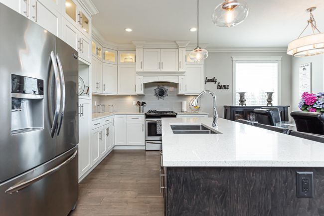 Kitchen with crown molding, a sink, decorative backsplash, stainless steel appliances, and dark wood-style flooring | Image 4