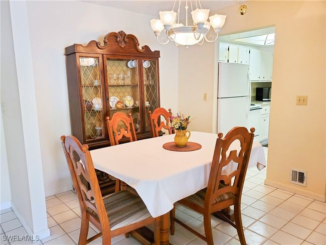 Dining room featuring baseboards, visible vents, light tile patterned floors, and an inviting chandelier | Image 8