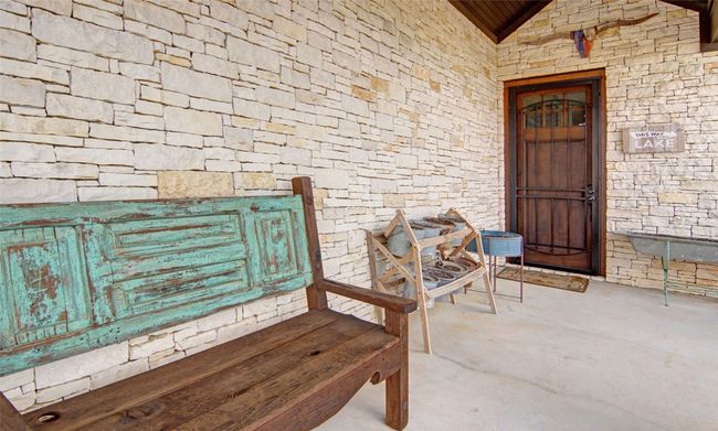 Doorway to property featuring stone siding and a porch | Image 22