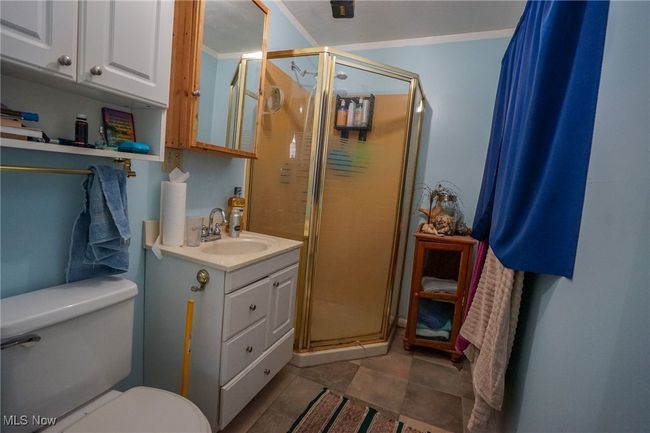 Bathroom featuring a shower stall, toilet, vanity, and tile patterned floors | Image 17