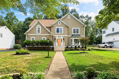 View of front facade with a garage and a front lawn | Image 1