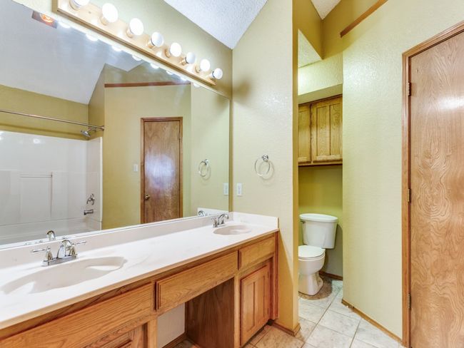 Full bathroom featuring double vanity, shower / bath combination, and tile patterned floors | Image 20
