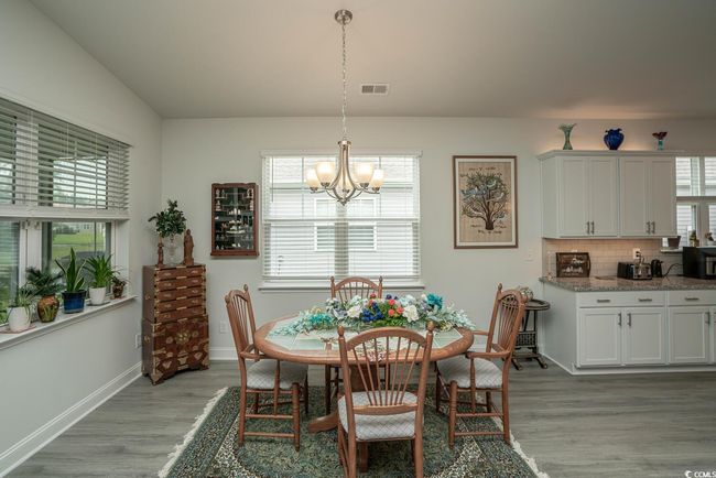 Dining area with a chandelier, light wood-style flooring, healthy amount of natural light, and baseboards | Image 27
