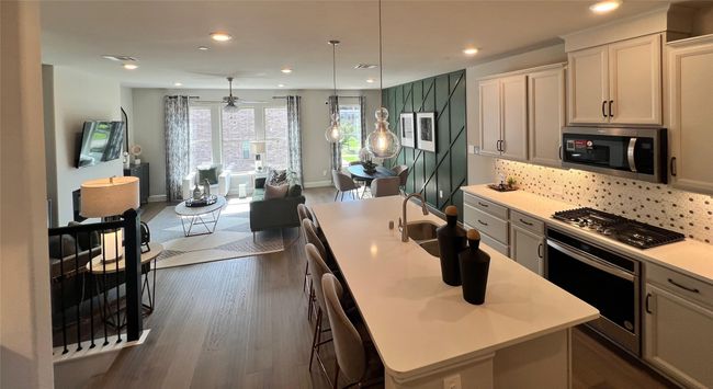 Kitchen with stainless steel appliances, open floor plan, light countertops, dark wood-style flooring, and recessed lighting | Image 7