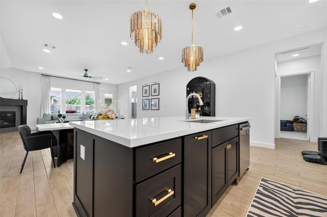 From this angle, the kitchen anchors the heart of the home with a spacious island that opens directly into the living and dining areas. The layout encourages easy movement and sightlines, offering a seamless blend of function and openness ideal for gatherings or daily routines. | Image 13