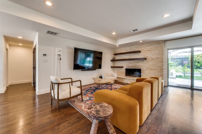 Living area featuring dark wood-type flooring, baseboards, recessed lighting, and a raised ceiling | Image 7