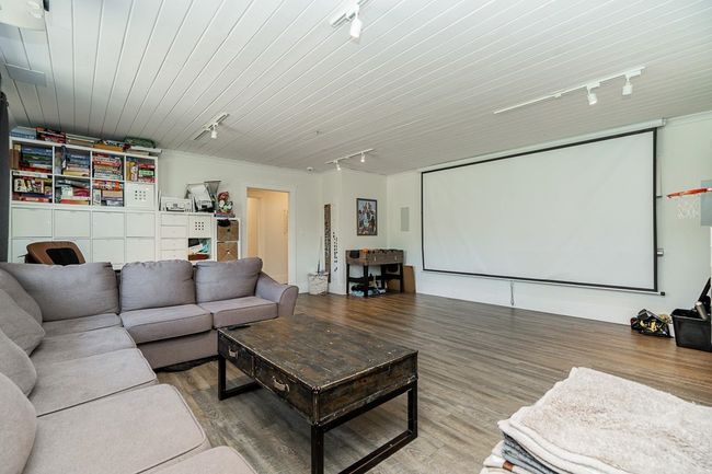 Home theater room featuring track lighting, wood finished floors, and wood ceiling | Image 18