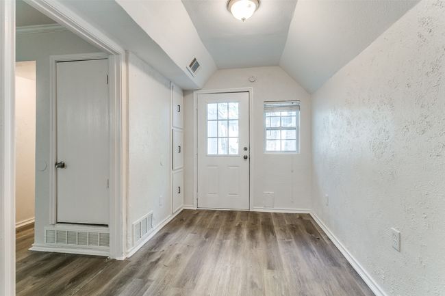 Doorway featuring wood finished floors, visible vents, and lofted ceiling | Image 12