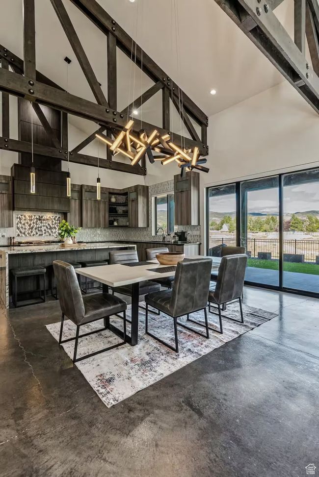Dining area featuring high vaulted ceiling, a wealth of natural light, beamed ceiling, and finished concrete flooring | Image 6