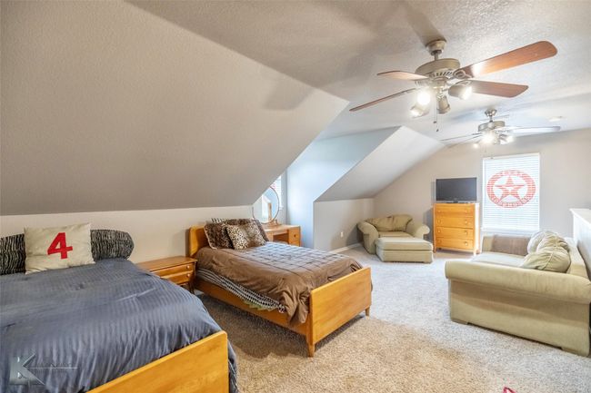 Carpeted bedroom featuring lofted ceiling, a textured ceiling, and a ceiling fan | Image 27