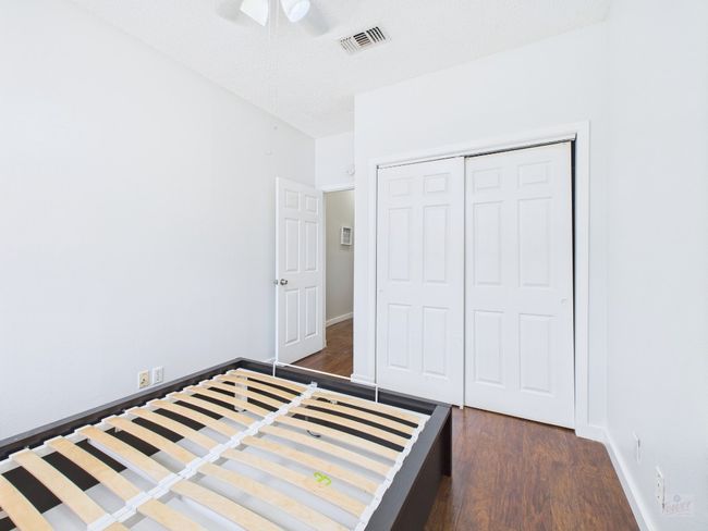 Unfurnished bedroom with dark wood-style flooring, a closet, and ceiling fan | Image 29