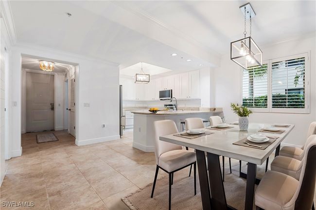 Virtually Stage Dining space featuring an inviting chandelier, light tile patterned floors, ornamental molding, and sink | Image 5