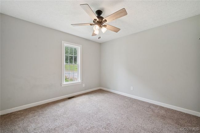 Carpeted spare room with baseboards, a ceiling fan, and a textured ceiling | Image 20