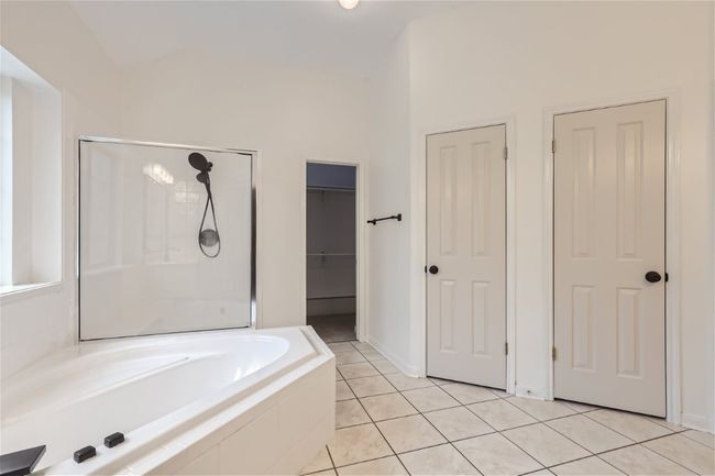 Bathroom with a bath, a stall shower, tile patterned flooring, a spacious closet, and vaulted ceiling | Image 20