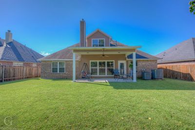 Rear view of property featuring a yard, a patio area, and ceiling fan | Image 2