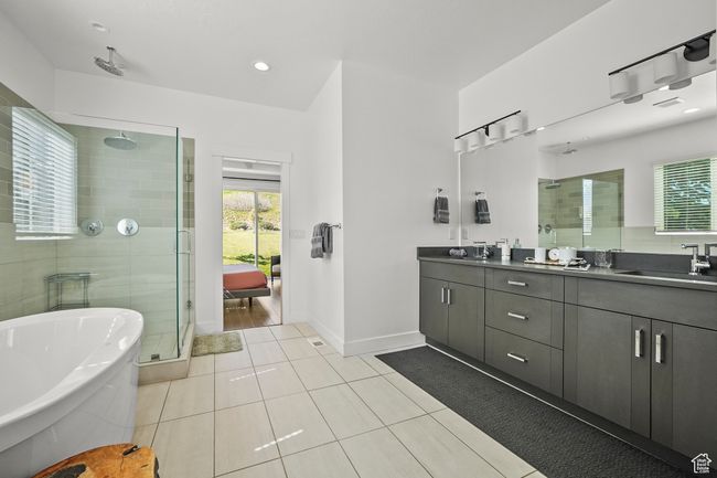 Full bathroom featuring a shower stall, double vanity, a soaking tub, and tile patterned floors | Image 18