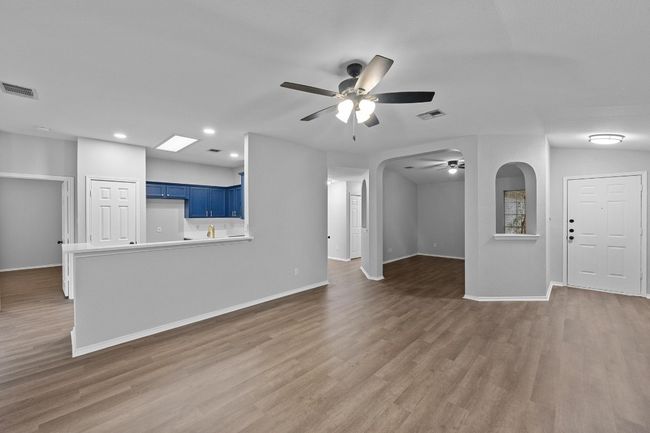 living room with a ceiling fan, wood finished floors, recessed lighting, and arched walkways | Image 8