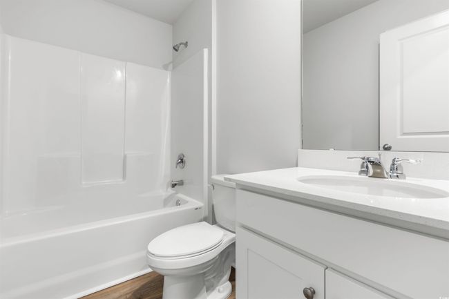 Full bathroom featuring vanity, toilet, wood-type flooring, and tub / shower combination | Image 6