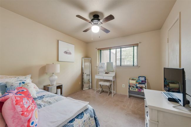 Bedroom featuring light colored carpet, a desk, baseboards, and ceiling fan | Image 25