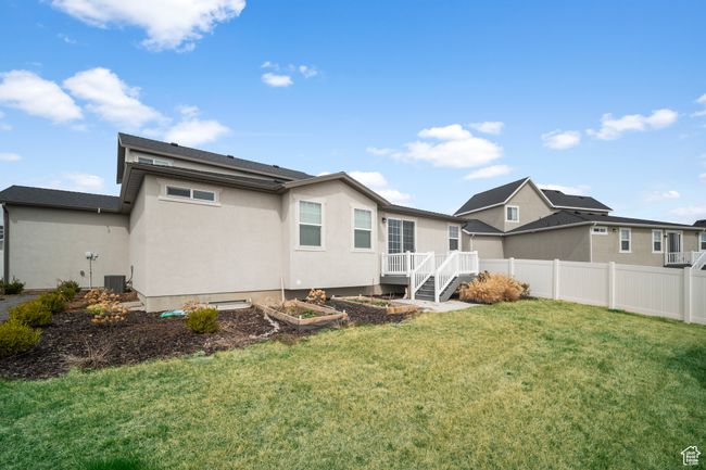 Back of house featuring a garden, fence, central air condition unit, stucco siding, and a lawn | Image 27